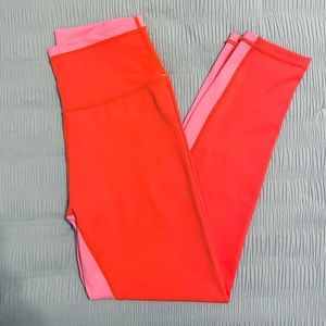 Wilo brand color block flame red (red-orange) leggings with pink detailing.